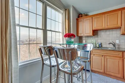 a kitchen with a glass table and stools in front of a window at Bayfront New Jersey Escape about 13 Mi to Times Square in Bayonne