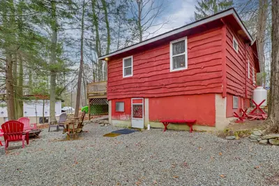 a red house with a table and chairs in front of it at Cozy Lake Wallenpaupack Cabin with Community Perks in Lake Ariel