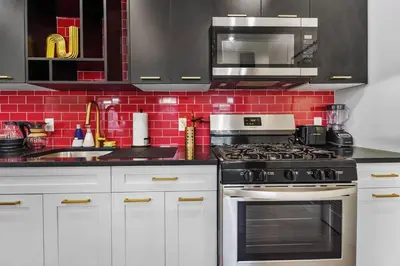 a kitchen with white cabinets and a stove top oven at Free Parking in Prime Area w King bd in Newark