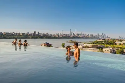 a group of people in a infinity pool with a city in the background at Free Parking in Prime Area w King bd in Newark