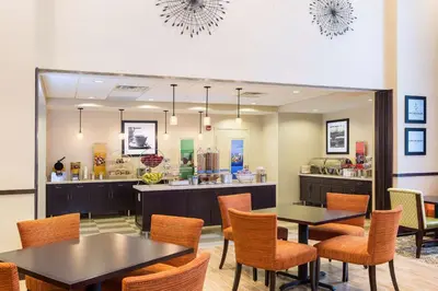 a restaurant with tables and chairs and a counter at Hampton Inn & Suites Philadelphia Montgomeryville in North Wales