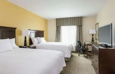 a hotel room with two beds and a flat screen tv at Hampton Inn & Suites Philadelphia Montgomeryville in North Wales