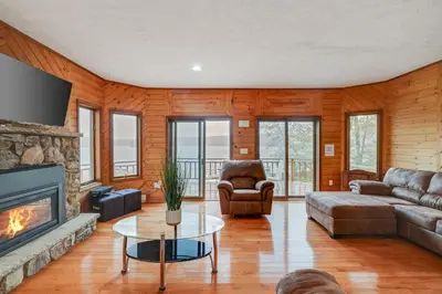 a living room with a couch and a fireplace at Lake Front, Hot Tub, Fire Pit, FP, Boats, Ski in Gouldsboro