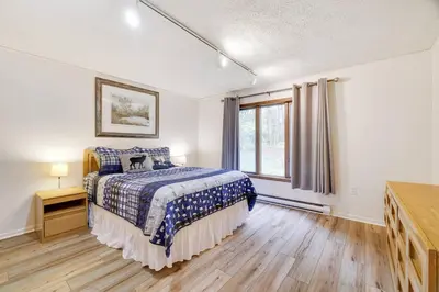a bedroom with a bed and a window at Lake Front, Hot Tub, Fire Pit, FP, Boats, Ski in Gouldsboro