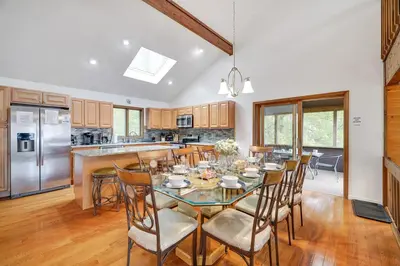 a kitchen and dining room with a table and chairs at Lake Front, Hot Tub, Fire Pit, FP, Boats, Ski in Gouldsboro
