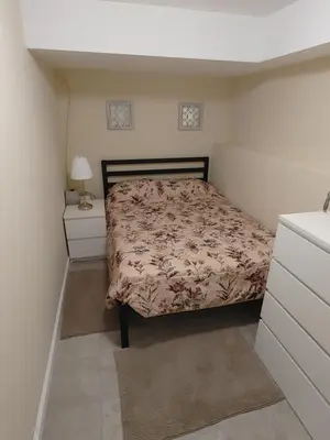 a small bedroom with a bed and a dresser at Guest house in a quiet peaceful area. in Mariners Harbor