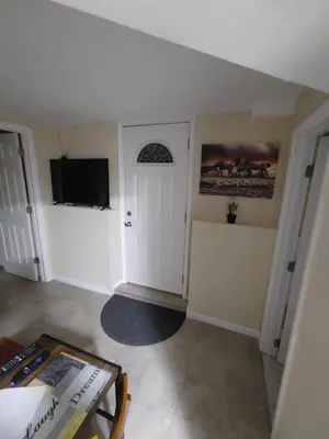 a room with a white door and a tv at Guest house in a quiet peaceful area. in Mariners Harbor
