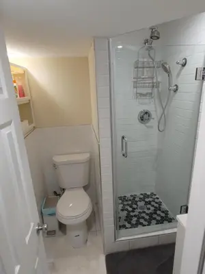 a small bathroom with a toilet and a shower at Guest house in a quiet peaceful area. in Mariners Harbor