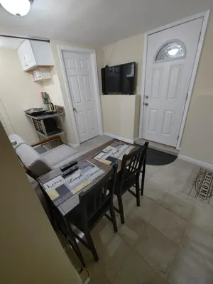 a dining room with a table and chairs and a kitchen at Guest house in a quiet peaceful area. in Mariners Harbor