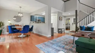 a living room and kitchen with a table and blue chairs at The Outpost Camelback Walk to Ski, Swim, and Fun! in Tannersville