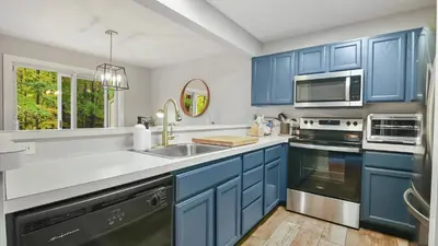 a kitchen with blue cabinets and a sink at The Outpost Camelback Walk to Ski, Swim, and Fun! in Tannersville