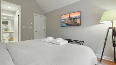 a bedroom with a white bed with a picture on the wall at The Outpost Camelback Walk to Ski, Swim, and Fun! in Tannersville