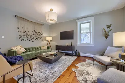 a living room with a green couch and a tv at The Tannery in Lancaster