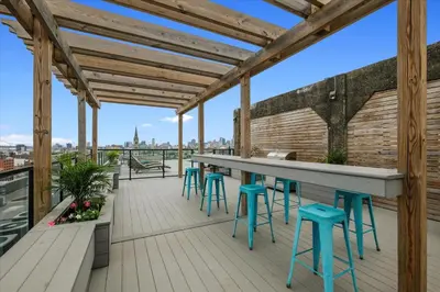 a bar on the roof of a building with blue stools at XL Studio -Deluxe Studio - Pool & Concierge in Philadelphia
