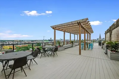 a patio with tables and chairs on a roof at XL Studio -Deluxe Studio - Pool & Concierge in Philadelphia