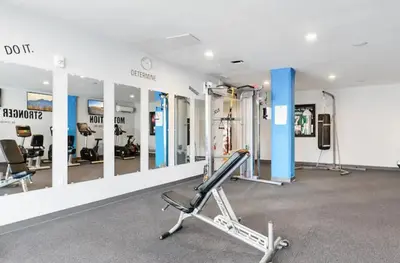 a room with a gym with a treadmill and mirrors at XL Studio -Deluxe Studio - Pool & Concierge in Philadelphia