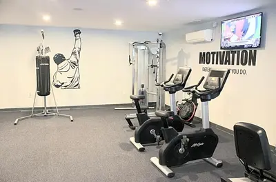a gym with cardio equipment and a flat screen tv at XL Studio -Deluxe Studio - Pool & Concierge in Philadelphia