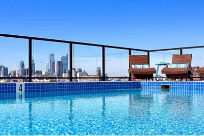 two chairs sitting on the edge of a swimming pool at XL Studio - Premier Studio with Gym Access in Philadelphia