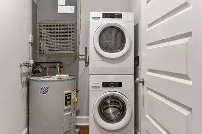 a laundry room with a washing machine and a washer at XL Studio - Stylish Studio with Rooftop Pool in Philadelphia