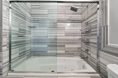 a bath tub in a bathroom with a glass wall at XL Studio - Stylish Studio with Rooftop Pool in Philadelphia