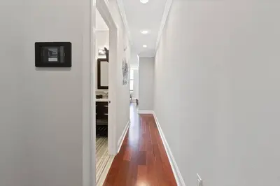 a hallway with white walls and a wooden floor at XL Studio - Stylish Studio with Rooftop Pool in Philadelphia