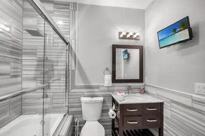 a bathroom with a tub and a toilet and a sink at XL Studio - Modern Studio with Rooftop Pool in Philadelphia