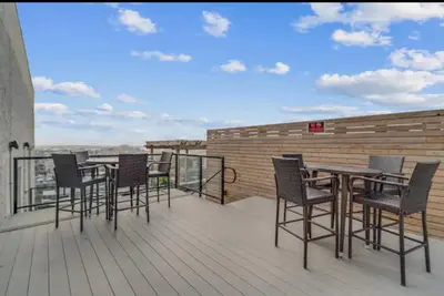 a group of chairs and tables on a balcony at XL Studio - Modern Studio with Rooftop Pool in Philadelphia