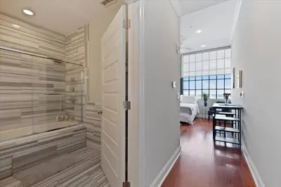 a bathroom with a walk in shower next to a bedroom at XL Studio - Luxury Studio Near Center City in Philadelphia