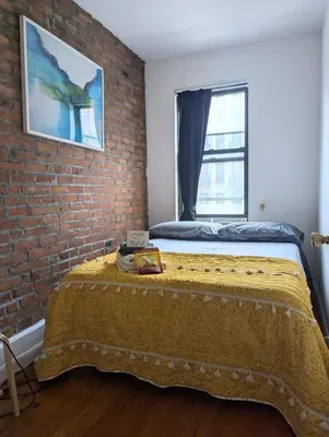 a bedroom with a bed against a brick wall at Chic One Bedroom Retreat in Downtown Manhattan in New York
