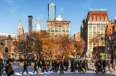 a group of people crossing a street in a city at Chic One Bedroom Retreat in Downtown Manhattan in New York