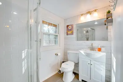 a white bathroom with a toilet and a sink at Arrowhead Lake Access Cabin with Resort Amenities in Pocono Lake