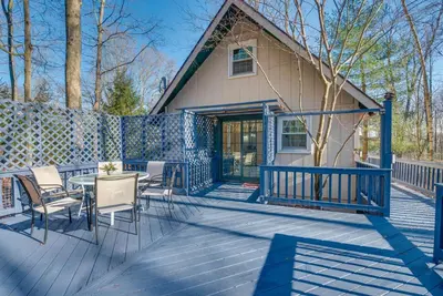 a house with a deck with a table and chairs at Arrowhead Lake Access Cabin with Resort Amenities in Pocono Lake