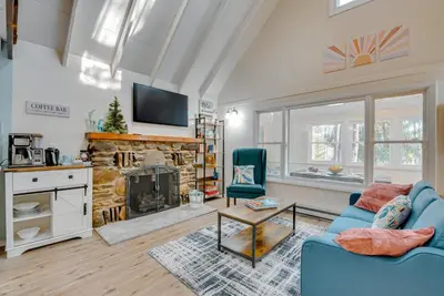 a living room with a blue couch and a fireplace at Arrowhead Lake Access Cabin with Resort Amenities in Pocono Lake