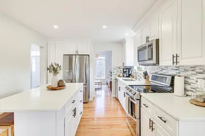 a white kitchen with white cabinets and a refrigerator at Beach and Lake Access Family Poconos Home with Deck in Tobyhanna