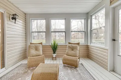 a screened in porch with two chairs and windows at Beach and Lake Access Family Poconos Home with Deck in Tobyhanna