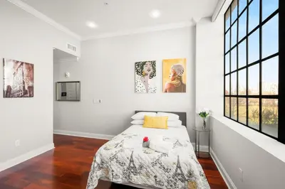 a bedroom with a bed in a room with windows at XL Studio - Chic Flat - Rooftop Pool & Gym in Philadelphia