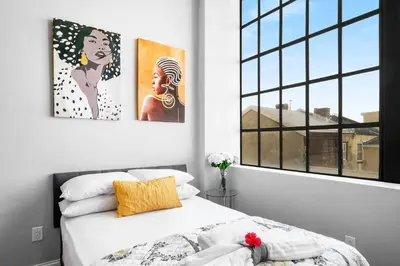 a bedroom with a bed with two paintings on the wall at XL Studio - Chic Flat - Rooftop Pool & Gym in Philadelphia