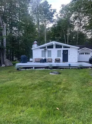 a small white house in a yard with a grass field at Luxury Poconos Home Near Skiing, Lakes, & Waterparks in Tobyhanna