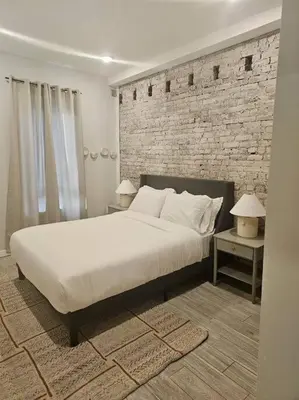 a bedroom with a large bed and a brick wall at Veau3 1BD 1BA minutes to NYC in Newark
