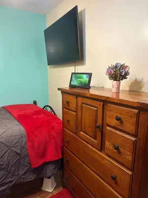 a bedroom with a dresser with a television on it at Genevieve’s comfort pad in Jersey City