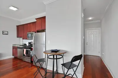 a kitchen with a table and chairs and a refrigerator at XL Studio - Magnificent Studio with Rooftop Pool in Philadelphia