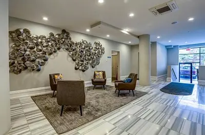 a lobby with chairs and a wall with a sculpture at XL Studio - Magnificent Studio with Rooftop Pool in Philadelphia