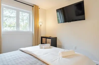 a bedroom with a bed with a television on the wall at Modern chalet for 8 people with Fireplace, Hot Tub and nearby Skiing in Tobyhanna