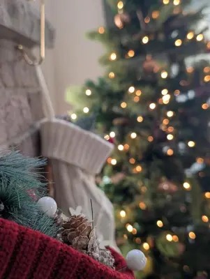 a christmas tree in front of a fireplace with a christmas ornament at Modern chalet for 8 people with Fireplace, Hot Tub and nearby Skiing in Tobyhanna