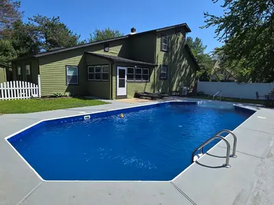 a large blue swimming pool in front of a house at The Edamame House in Nazareth