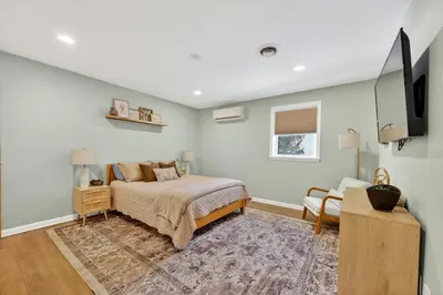 a bedroom with a bed and a flat screen tv at The Edamame House in Nazareth