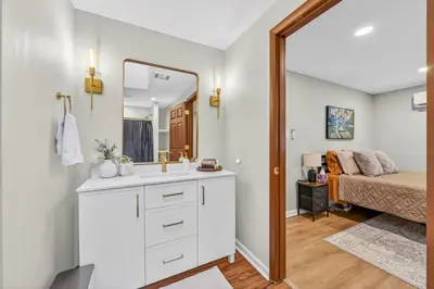 a bathroom with a sink and a mirror and a bed at The Edamame House in Nazareth