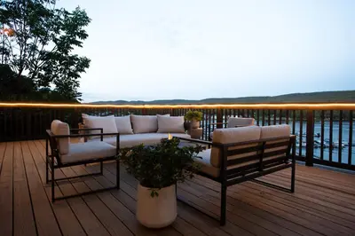 a patio with a couch and chairs on a deck at Lakeview Villa with Private Hot Tub, Firepit & Spacious Decks with Breathtaking Cliff Views in Greenwood Lake