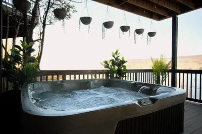 a hot tub on a deck with potted plants at Lakeview Villa with Private Hot Tub, Firepit & Spacious Decks with Breathtaking Cliff Views in Greenwood Lake
