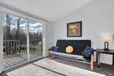 a living room with a couch and a large window at Heart of Pocono Mtn 3bd 2ba Gameroom Pocono Raceway in Long Pond